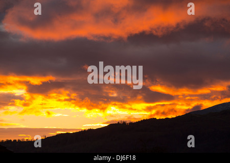 Un arbre de lumière tire sur une lacune dans les nuages au coucher du soleil, à l'origine d'une lueur dorée, Ambleside, Lake District, UK, Banque D'Images