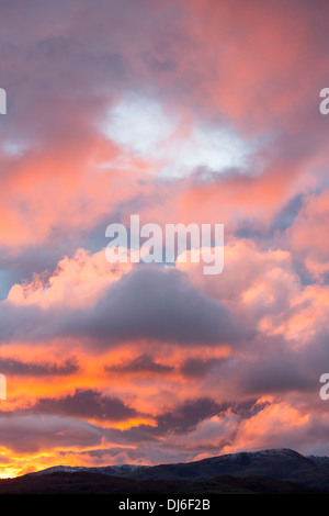 Un arbre de lumière tire sur une lacune dans les nuages au coucher du soleil, à l'origine d'une lueur dorée, Ambleside, Lake District, UK, Banque D'Images