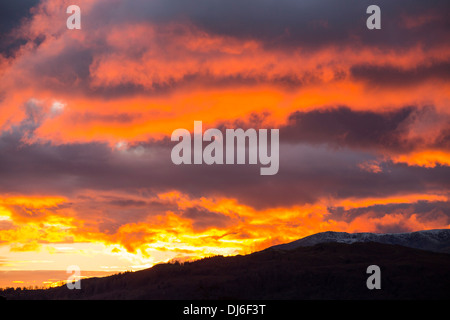 Un arbre de lumière tire sur une lacune dans les nuages au coucher du soleil, à l'origine d'une lueur dorée, Ambleside, Lake District, UK, Banque D'Images