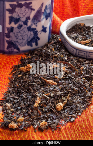 Image de feuilles de thé au jasmin chinois avec un pot en céramique bleu et blanc. Banque D'Images