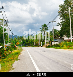 La route asphaltée dans la jungle avec le mont, Krabi, Thaïlande Banque D'Images
