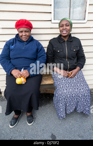 L'Afrique du Sud, Cape Town, Guguletu Township. Deux femmes assises sur un banc. Banque D'Images