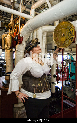 Jeune femme vêtue de Steampunk posant avec les commandes du moteur sur le Belle of Louisville Banque D'Images