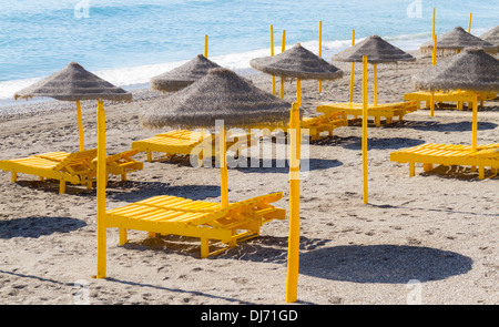 Des chaises longues de plage vide sur une plage espagnole sous le soleil d'hivers jour Banque D'Images