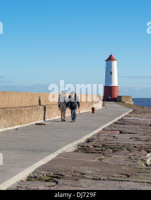 Couple marchant le long de la jetée Berwick upon Tweed, Northumberland, England, UK Banque D'Images