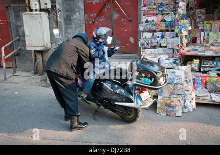 Père et son fils sur un scooter à Beijing, Chine Banque D'Images