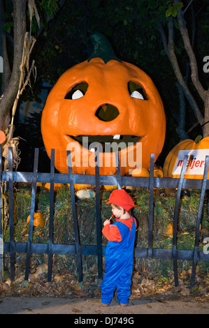 Enfant déguisé en Mario fStanding à côté de Giant Jack-O-Lantern Halloween Party le Zoo de Louisville à Louisville Kentucky Banque D'Images