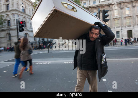 Londres, 23 novembre 2011. Un manifestant arrive à Whitehall portant un cercueil pour être transportées sur une marche de Downing Street à l'ambassade des Etats-Unis pour protester contre les attaques de drones qui tuent des civils innocents. Crédit : Paul Davey/Alamy Live News Banque D'Images