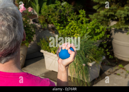 Senior Woman flexing balle anti-stress, USA Banque D'Images