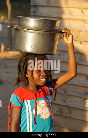 Jeune fille malgache transportant sur la tête des pots, Morondava, Madagascar Banque D'Images