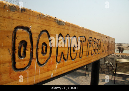 'Ne pas nourrir les animaux" signe à Etosha National Park. C'est un parc national dans le nord-ouest de la Namibie. Le parc a été proclamé une réserve de chasse le 22 mars 1907 dans l'ordonnance 88 par le gouverneur de l'Afrique du Sud-ouest allemand, le Dr Friedrich von Lindequist. Banque D'Images