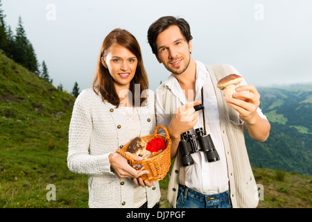 Champignons - jeune couple à la recherche et à la recherche de cèpes dans les montagnes Banque D'Images