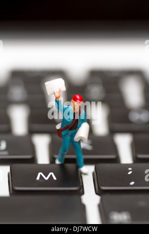 Figure miniature avec du papier journal sur un clavier, une image symbolique pour l'information, courrier électronique, epaper Banque D'Images