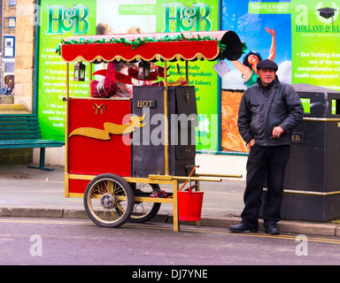Vendeur de rue, la vente de châtaignes grillées chaudes en hiver, à Whitby, North Yorkshire UK Banque D'Images