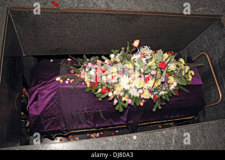 Un cercueil dans une morgue avec un arrangement floral Banque D'Images