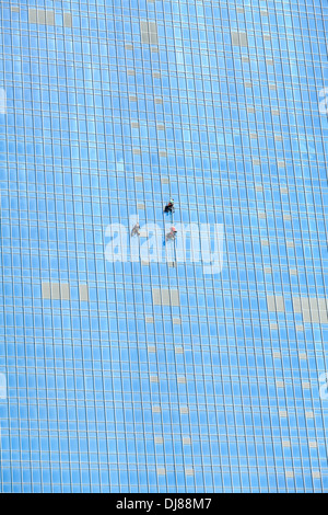 Les grimpeurs industriels travaillant sur miroir façade gratte-ciel Banque D'Images