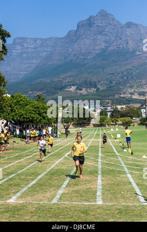 Fille courir vers la ligne d'arrivée lors d'une journée de sport, les champs de l'école St Georges, Cape Town, Afrique du Sud Banque D'Images