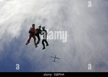 Cette équipe de parachutisme freefly a sauté d'un avion et tient les mains ensemble. C'est amusement pour tous de voler librement dans le ciel. Banque D'Images