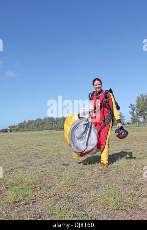 Cette fille débarque avec son parachutiste parachute et est maintenant très heureux d'être enregistrer sur le sol. Banque D'Images