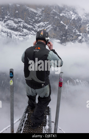 Cavalier de base se prépare pour base jump. Il est de ce fait contrôler son casque avant de quitter la rampe. Banque D'Images