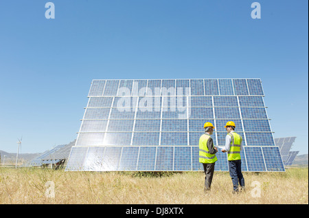 L'examen des travailleurs panneau solaire in rural landscape Banque D'Images