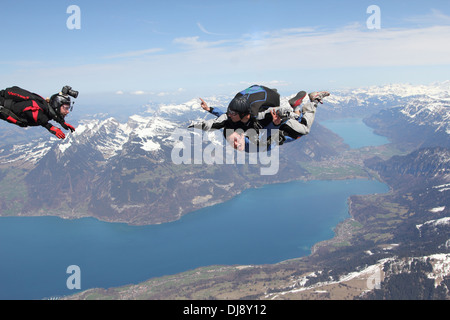 Skydiving Tandem passagers s'amuse pendant la chute libre sur un beau paysage. Un vidéoman extérieur est ainsi filmer. Banque D'Images