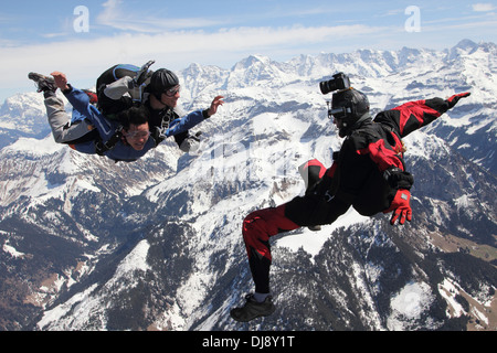 Skydiving Tandem passagers s'amuse pendant la chute libre sur un beau paysage. Un vidéoman extérieur est ainsi filmer. Banque D'Images