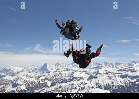 Skydiving Tandem passagers s'amuse pendant la chute libre sur un beau paysage. Un vidéoman extérieur est ainsi filmer. Banque D'Images