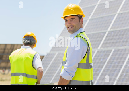 Marche des travailleurs par des panneaux solaires in rural landscape Banque D'Images