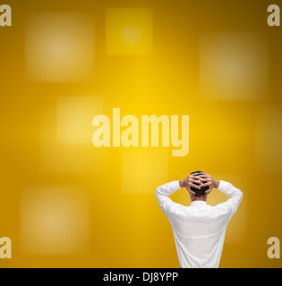 Businessman standing back to camera hands on head Banque D'Images