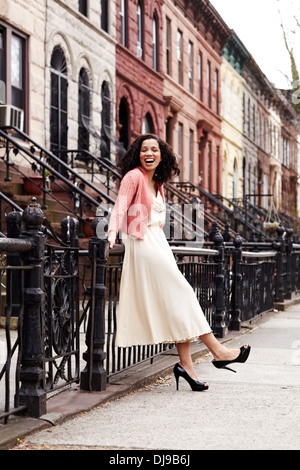 Mixed Race woman smiling on city street Banque D'Images