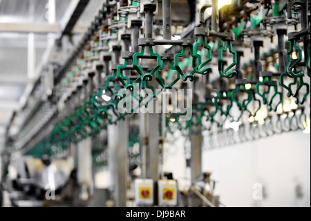 Des crochets vides dans une usine de transformation de viande de volaille Banque D'Images