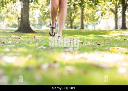 Close up de femmes portaient des sandales pieds marcher sur l'herbe Banque D'Images