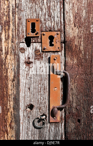 Les plaques de serrure ancienne et la poignée sur porte en chêne patiné - France. Banque D'Images