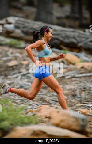 Mixed Race woman running in woods Banque D'Images