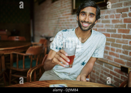 Asian man drinking beer in pub Banque D'Images