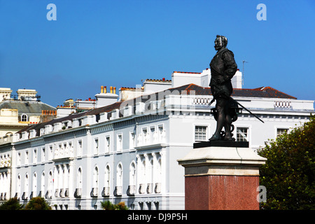 Une statue de bronze sur un socle avec un décor de maisons de ville classique. Banque D'Images