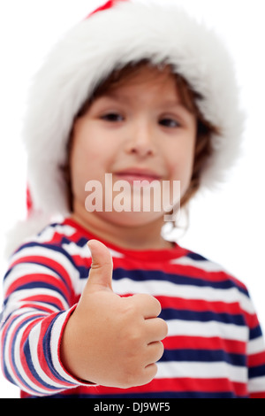 Adorable petit boy wearing santa hat et vous donnant Thumbs up - focus on hand Banque D'Images