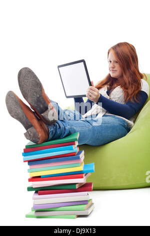 Des taches de rousseur girl using tablet computer à la maison au lieu de la lecture Banque D'Images