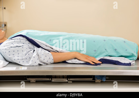Patient allongé sur une table à rayons X Banque D'Images