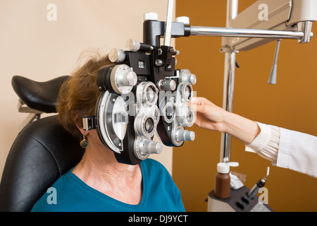 Femme subissant l'examen des yeux avec Phoropter Banque D'Images