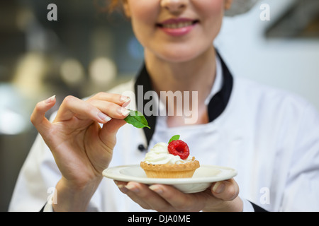 Happy chef chefs presenting petit gâteau sur la plaque Banque D'Images