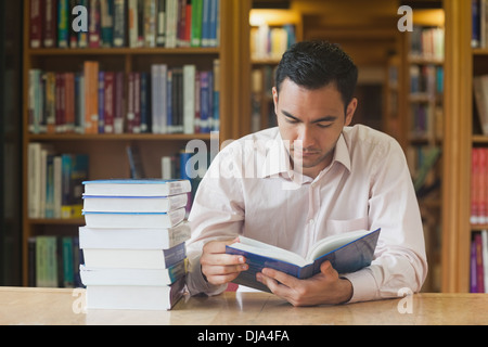 Homme séduisant intellectuelle concentrée un livre de lecture Banque D'Images