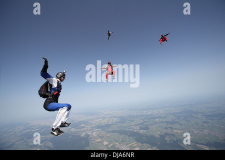 L'équipe de parachutisme Freefly formation La formation est de retour/sit-survolant un paysage spectaculaire de la terre et les champs dans le ciel avec 130 MPH. Banque D'Images