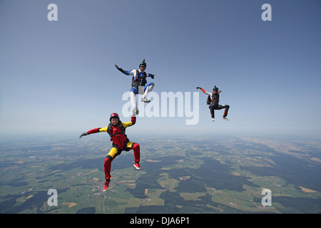 L'équipe de parachutisme Freefly formation La formation est de retour/sit-survolant un paysage spectaculaire de la terre et les champs dans le ciel avec 130 MPH. Banque D'Images