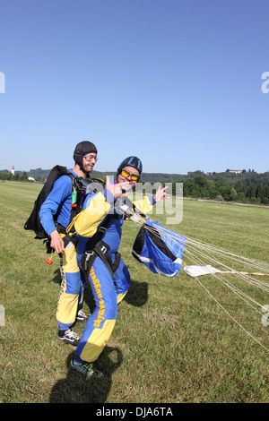 Ce sont des parachutistes avec leurs parachutes et maintenant ils sont très heureux d'être enregistrer sur le sol. Banque D'Images