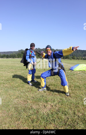 Ce sont des parachutistes avec leurs parachutes et maintenant ils sont très heureux d'être enregistrer sur le sol. Banque D'Images