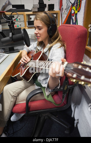 En se concentrant assez singer recording and playing guitar Banque D'Images
