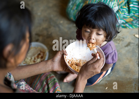 Enfants mayas est alimenté en Aqua Escondida, Solola, Guatemala. Banque D'Images