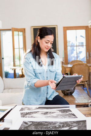 Mixed Race photographer using digital tablet Banque D'Images